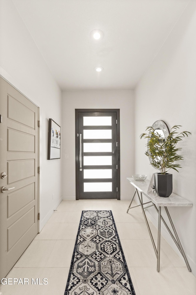 entrance foyer with recessed lighting, light tile patterned flooring, and baseboards