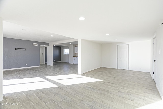 unfurnished living room with wood tiled floor, visible vents, baseboards, and recessed lighting