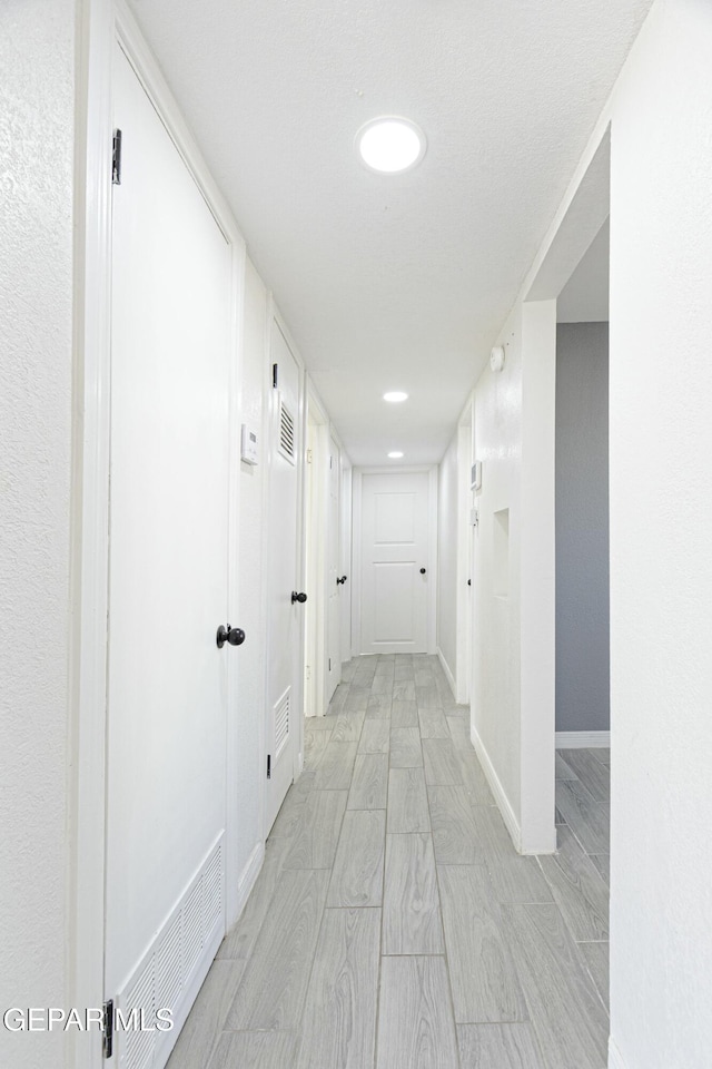 hall with visible vents and baseboards