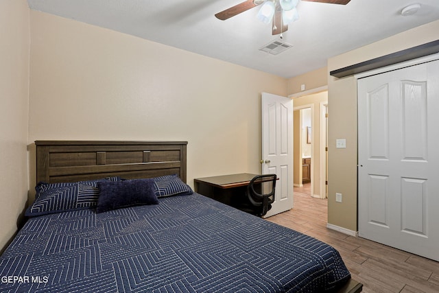 bedroom with ceiling fan, visible vents, baseboards, and wood finish floors