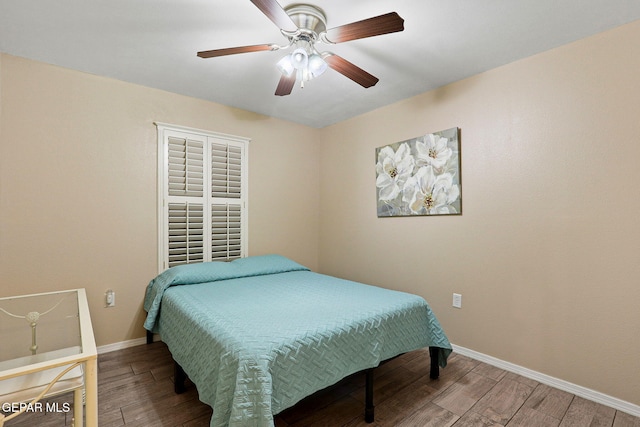 bedroom featuring ceiling fan, baseboards, and wood finished floors