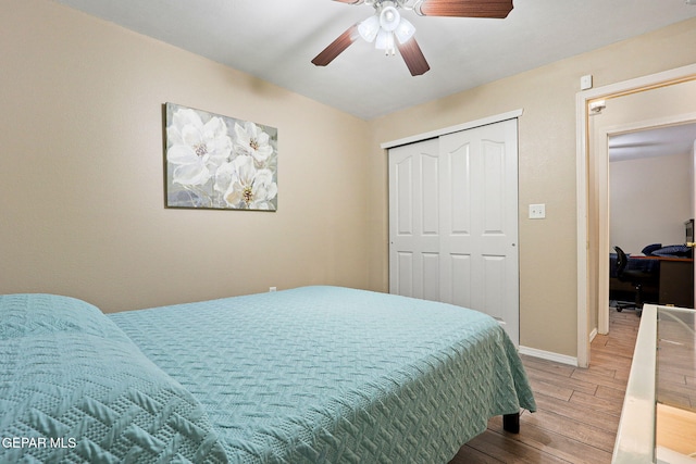 bedroom with a closet, ceiling fan, baseboards, and wood finished floors