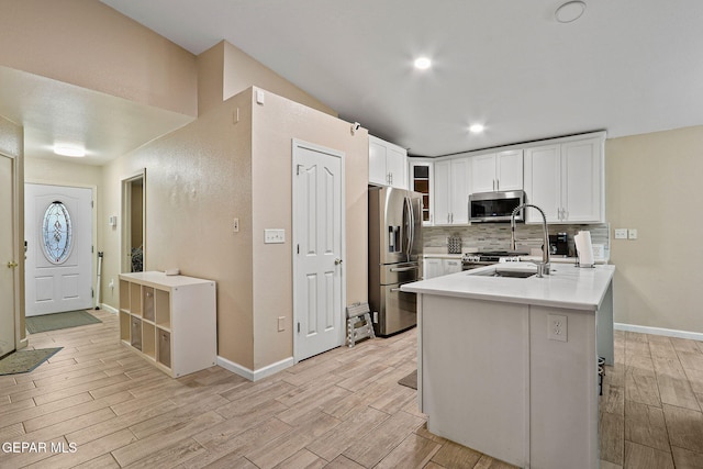 kitchen with white cabinets, glass insert cabinets, appliances with stainless steel finishes, light countertops, and a sink