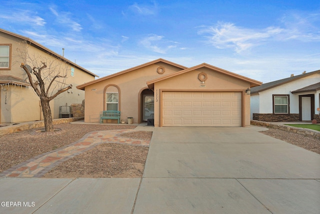 view of front of house with a garage, driveway, and stucco siding