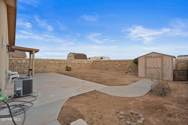 view of patio / terrace with an outbuilding, a fenced backyard, a storage shed, and central AC unit