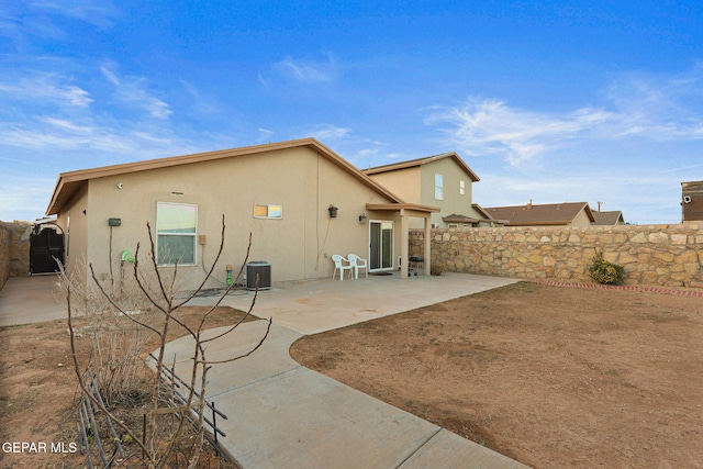 back of house with cooling unit, a patio area, a fenced backyard, and stucco siding