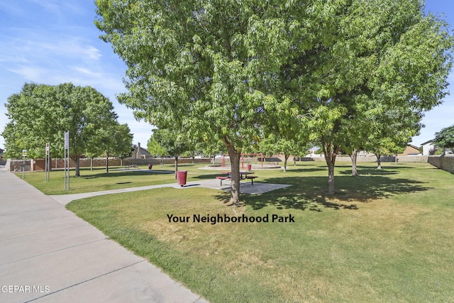 view of community featuring fence and a yard