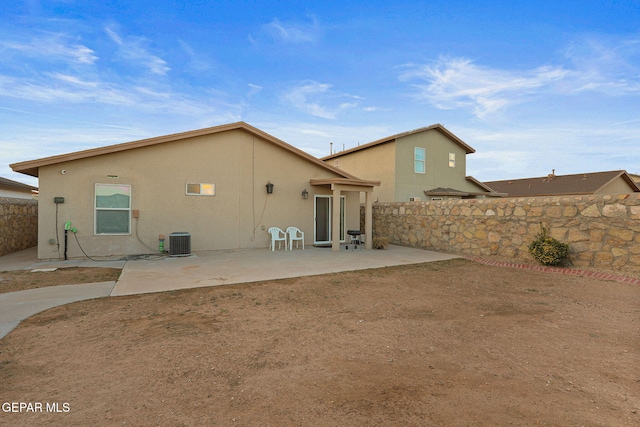 back of property featuring a patio area, a fenced backyard, central AC, and stucco siding