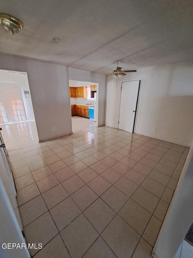 empty room featuring ceiling fan, a textured ceiling, and light tile patterned floors