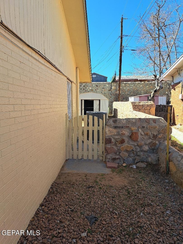 view of yard with a gate, fence, and an outdoor structure