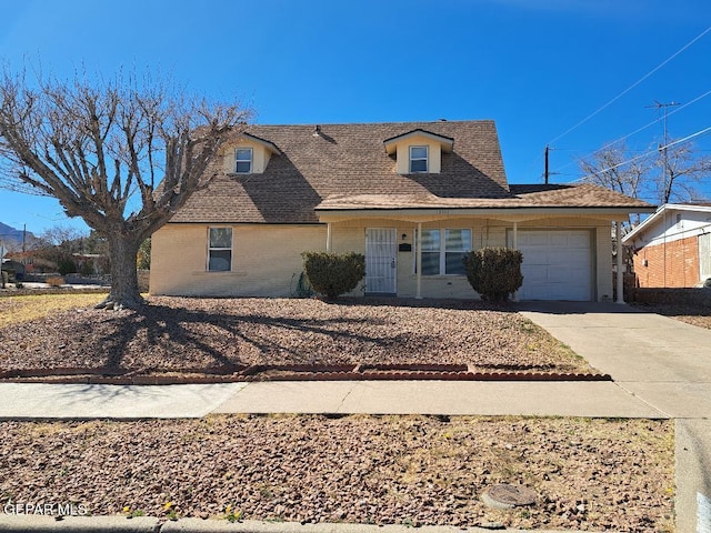 view of front of property with an attached garage, roof with shingles, concrete driveway, and brick siding