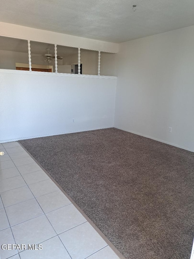 empty room featuring a ceiling fan and light carpet