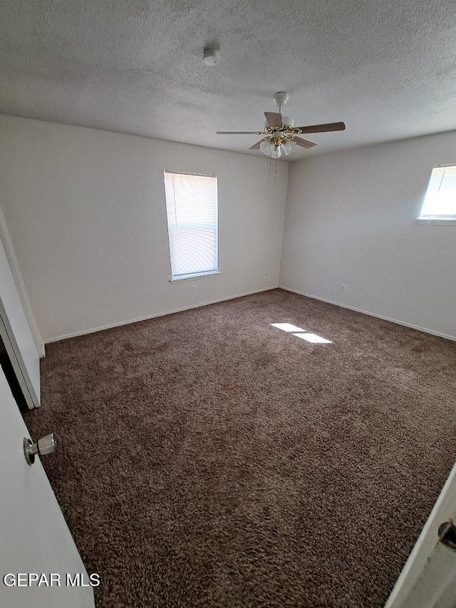 carpeted spare room featuring a textured ceiling and a ceiling fan