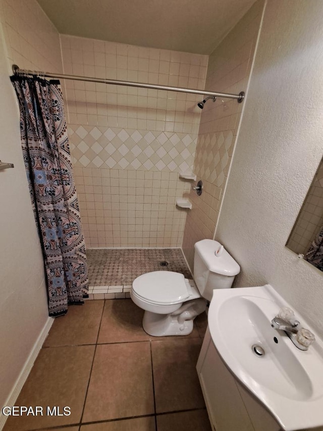 full bath with a textured wall, tile patterned flooring, toilet, a sink, and a shower stall