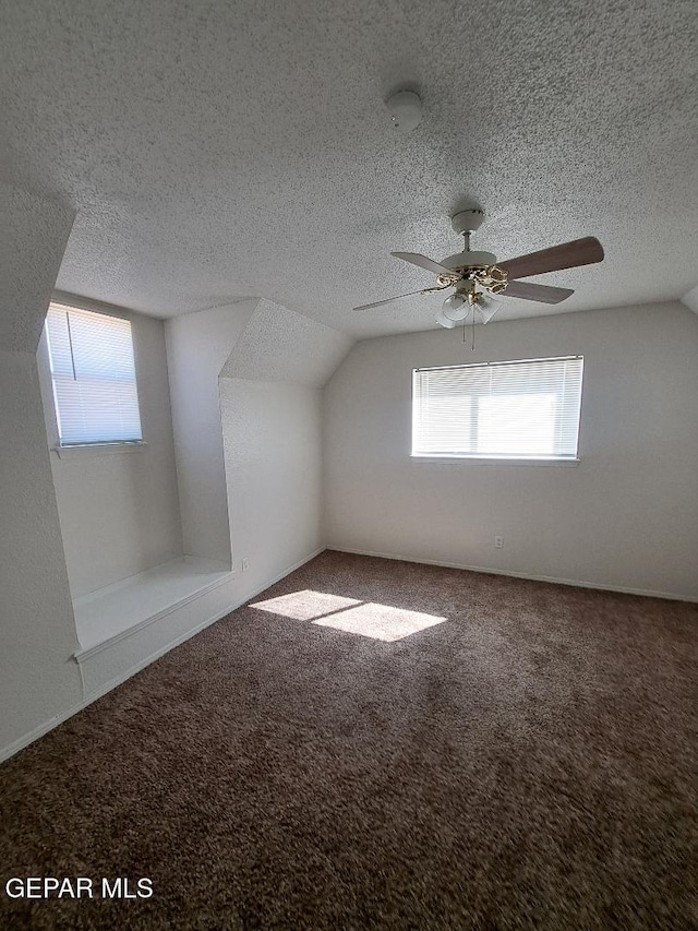 bonus room with carpet floors, lofted ceiling, and a textured ceiling