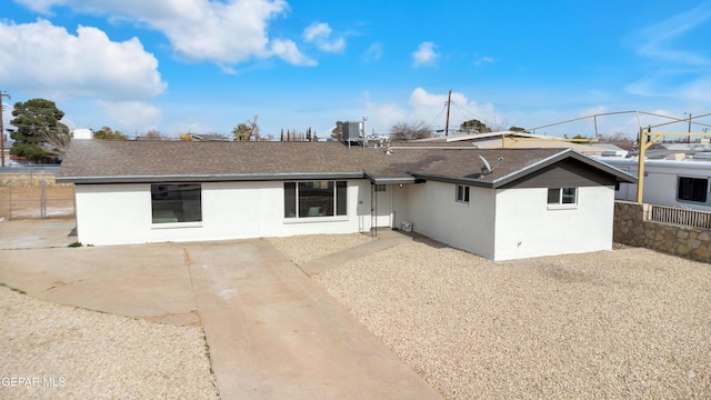 back of house with roof with shingles, fence, and a patio