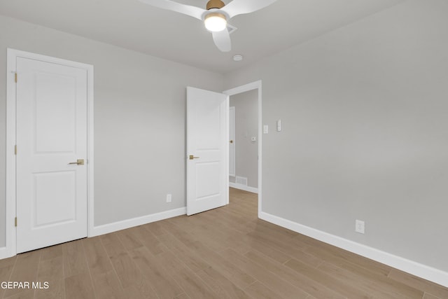 unfurnished bedroom featuring ceiling fan, visible vents, light wood-style flooring, and baseboards