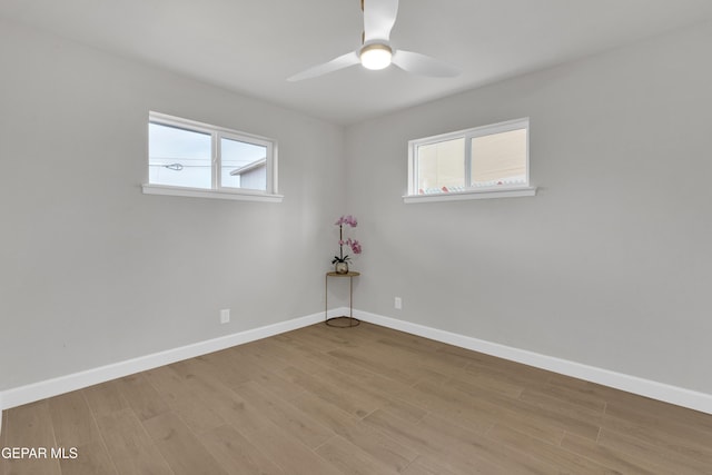 empty room with light wood-type flooring, baseboards, and a ceiling fan