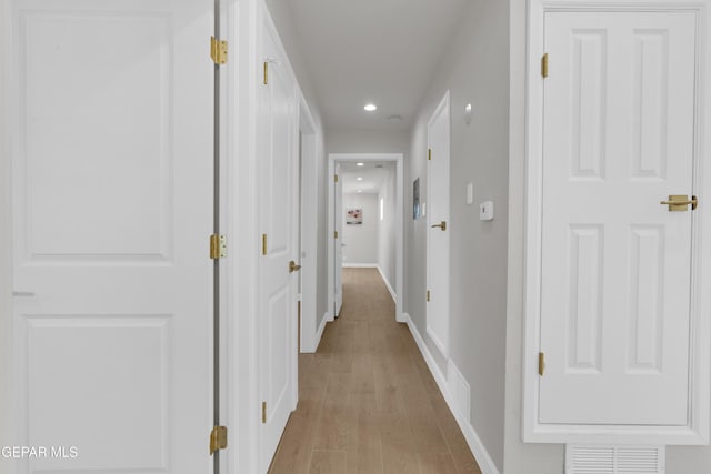 hallway with baseboards, recessed lighting, visible vents, and light wood-style floors