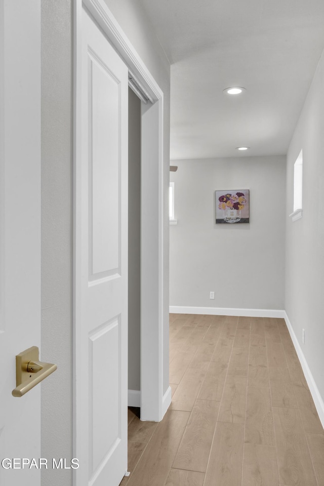 hall featuring a wealth of natural light, recessed lighting, light wood-style flooring, and baseboards