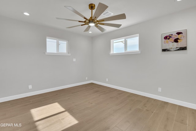 empty room featuring light wood-type flooring, a healthy amount of sunlight, baseboards, and recessed lighting