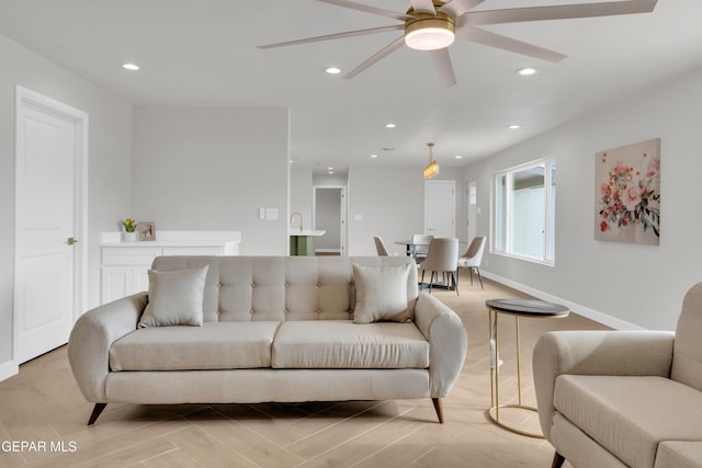 living area featuring baseboards, a ceiling fan, and recessed lighting