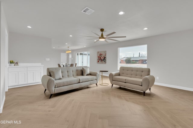 living room featuring baseboards, visible vents, and recessed lighting