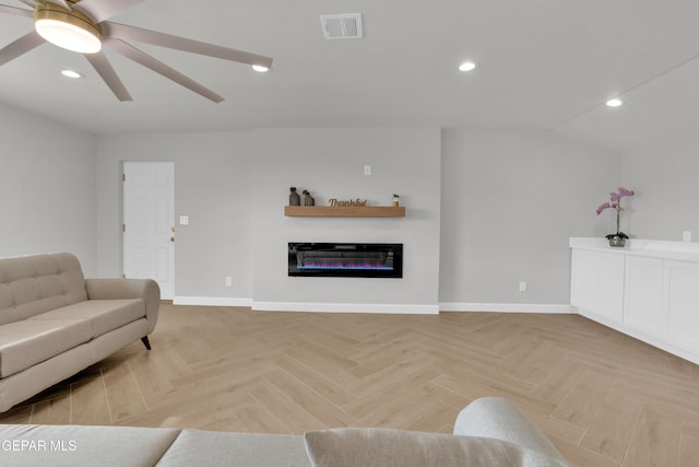 living room with recessed lighting, visible vents, baseboards, and a glass covered fireplace