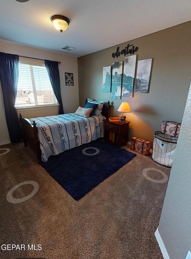 bedroom featuring carpet floors, visible vents, and a textured ceiling