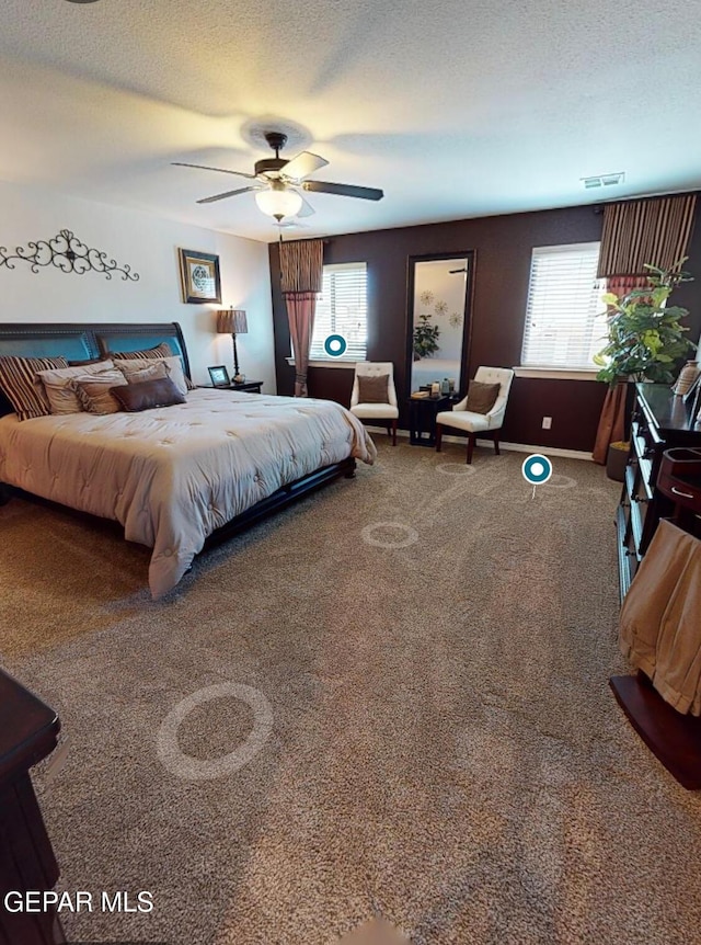 carpeted bedroom with visible vents, ceiling fan, a textured ceiling, and multiple windows