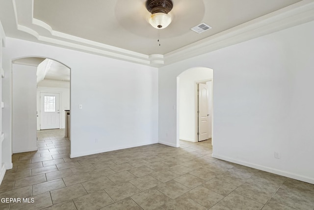 unfurnished room with arched walkways, a raised ceiling, visible vents, and a ceiling fan