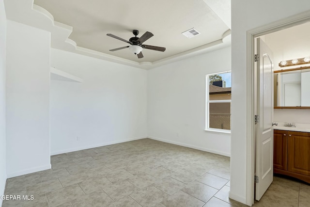 unfurnished bedroom featuring light tile patterned floors, baseboards, visible vents, ensuite bathroom, and a tray ceiling