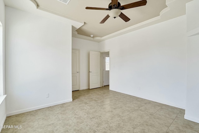 spare room featuring ceiling fan, light tile patterned floors, visible vents, baseboards, and a raised ceiling