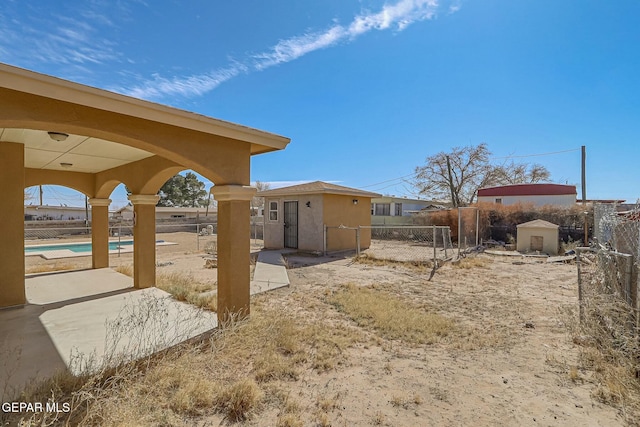 view of yard with a fenced in pool, a fenced backyard, an outdoor structure, and a shed