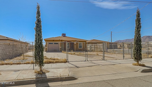 view of front of property with driveway, a fenced front yard, an attached garage, and a gate