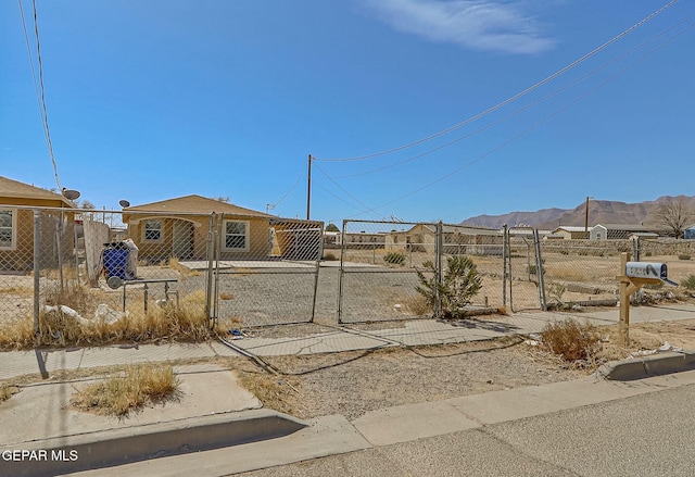 view of yard featuring a fenced front yard, a gate, and a mountain view