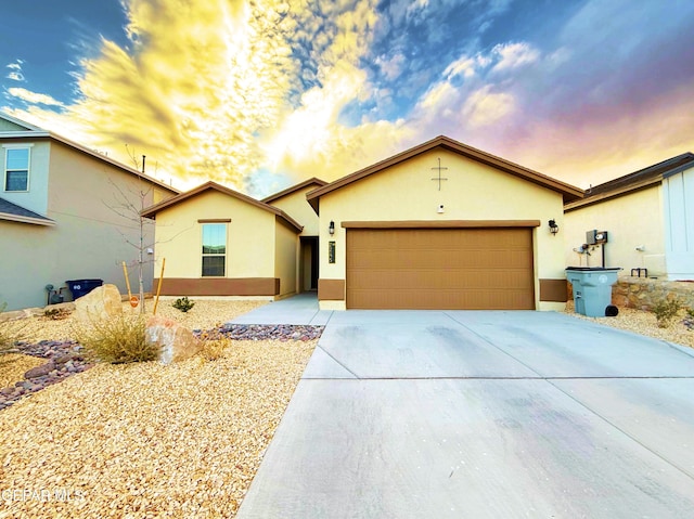 ranch-style home with driveway, an attached garage, and stucco siding