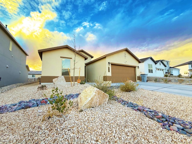 view of front of house featuring a garage, concrete driveway, and stucco siding