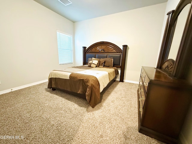 bedroom with light carpet, visible vents, and baseboards