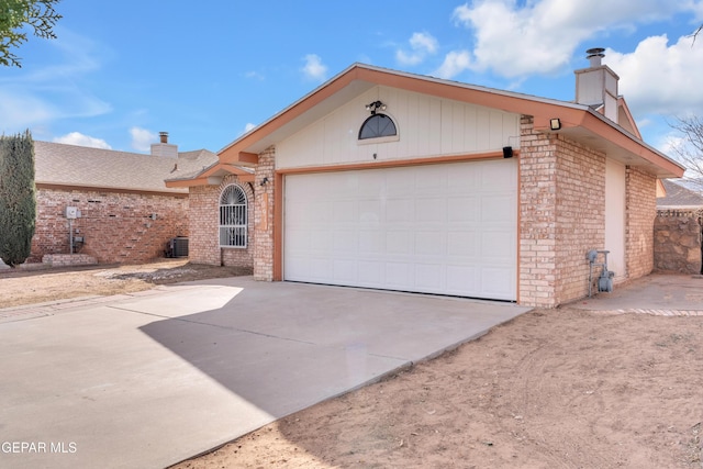 ranch-style home featuring a garage, concrete driveway, brick siding, and a chimney