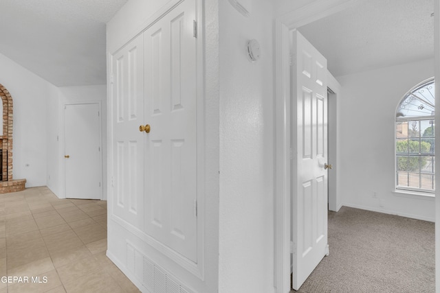 hallway featuring light colored carpet and light tile patterned floors