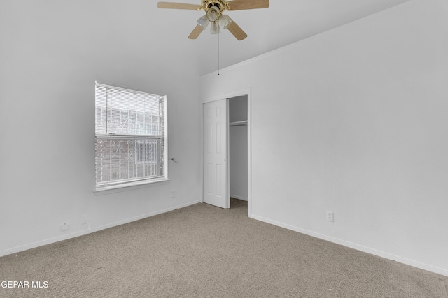 unfurnished bedroom featuring light carpet, a ceiling fan, baseboards, and a closet