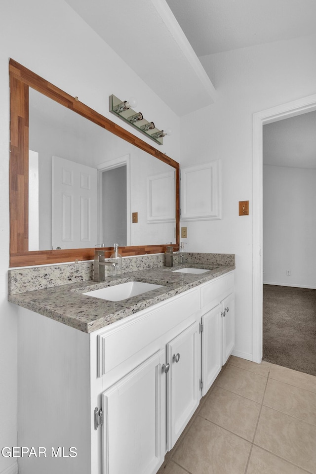 bathroom with double vanity, a sink, and tile patterned floors