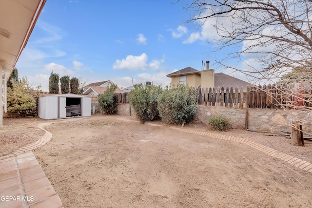 view of yard with a shed, fence, and an outdoor structure