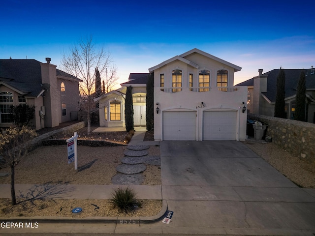 view of front of house featuring driveway, a garage, and stucco siding