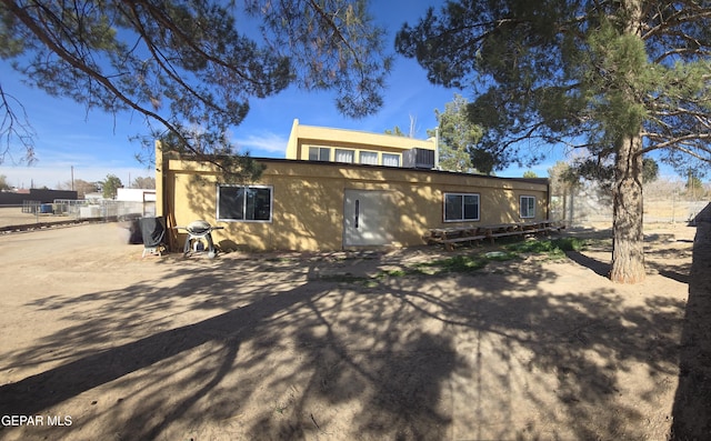 back of property featuring fence and stucco siding