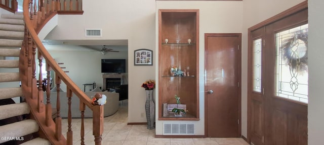 foyer entrance featuring ceiling fan, stairs, and visible vents