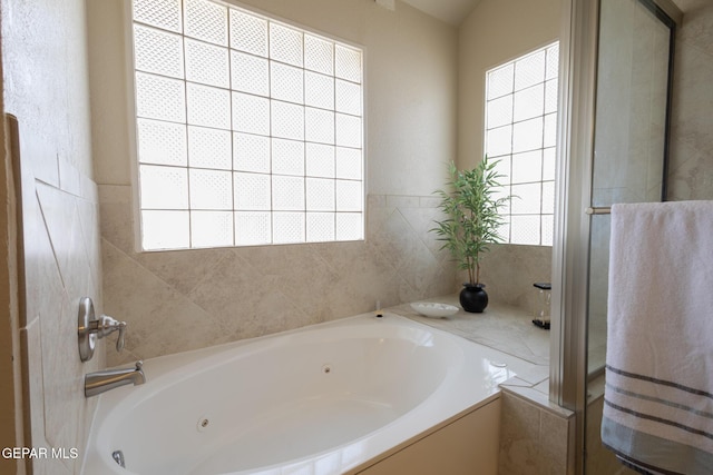 bathroom featuring a tub with jets and an enclosed shower