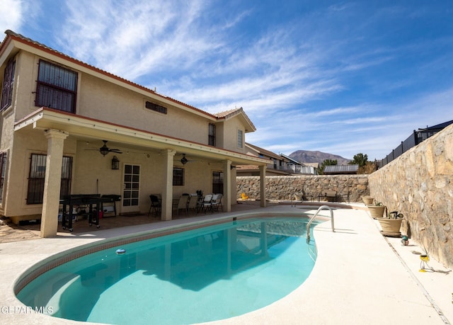 view of pool featuring ceiling fan, a patio, a fenced backyard, a mountain view, and a fenced in pool