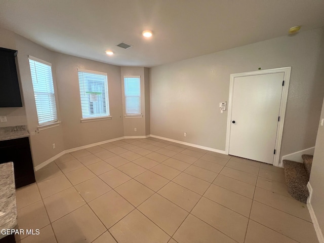 unfurnished living room with light tile patterned floors, stairs, visible vents, and baseboards